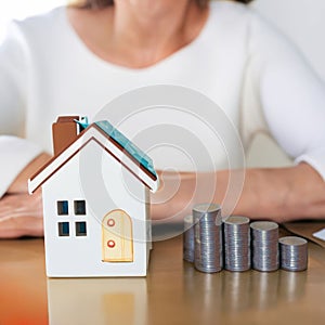 House model and coin holder money on the table for finance and banking concepts. Property investment mortgage and home