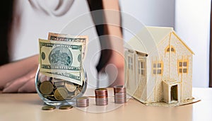 House model and coin holder money on the table for finance and banking concepts. Property investment mortgage and home