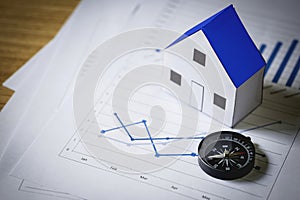 House model and compass on plan background, Real estate concept