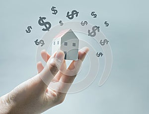 House model on human hands with dollar icon.Savings money,real estate