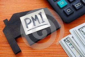 House model and memo stick with letters PMI Private Mortgage Insurance.