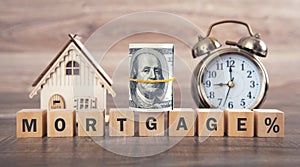 House model, money, alarm clock and word Mortgage on wooden cubes