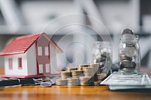 House model and money coins saving for concept saving money for buying a house, investment mortgage finance, and home loan