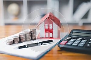 House model and money coins saving for concept saving money for buying a house, investment mortgage finance, and home loan