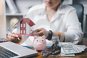 House model and money coins saving for concept saving money for buying a house, investment mortgage finance, and home loan