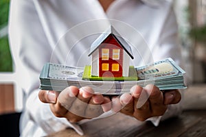 House model and money in hand