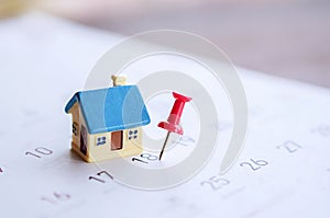 House model and red pin mark on calendar, due date for home payment ,property reminder concept
