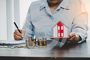 House model with stack coins, business hand is planning savings money of coins for buy home. concept for property ladder, mortgage