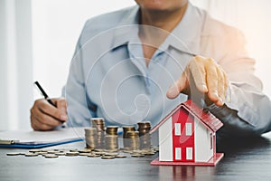 House model with stack coins, business hand is planning savings money of coins for buy home. concept for property ladder, mortgage