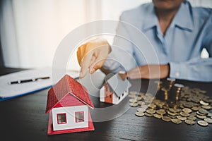 House model with stack coins, business hand is planning savings money of coins for buy home. concept for property ladder, mortgage