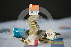 House model on top of stack of money as growth of mortgage credit, Concept of property management. Invesment and Risk Management.