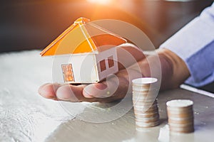 House models and coin in human hands, Mortgage concept by money