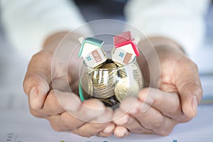 House models and coin in human hands, Mortgage concept by money house from the coins