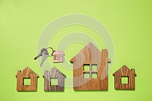 House models and keys on light green background, flat lay. Space for text