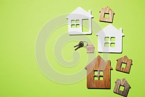 House models and keys on light green background, flat lay. Space for text