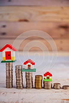 House models with stacked coins at wooden table business asset c