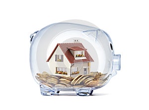 House on money inside transparent piggy bank