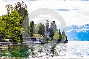 House near lake Thun and travek ship with view of Bernese Alps mountain Berne, Switzerland photo