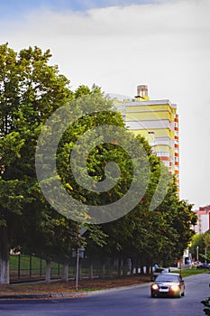 a house near trees and a road with a car