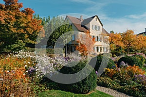 House with nice garden in fall. Flowers in the City Park of Bietigheim-Bissingen, Baden-Wuerttemberg, Germany, Europe