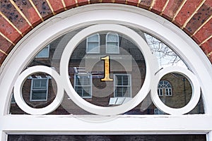 House number 1 in gold, on a transom window.