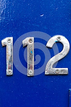 House number 112 on a blue wooden front door