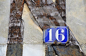 House number 16 on antique rustic wall, old, rusty enamel sign