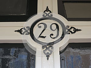 house number 29 painted in black on a woorden front door
