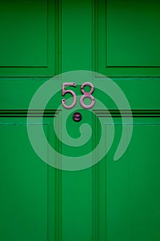 House number 58 on a dark green wooden front door