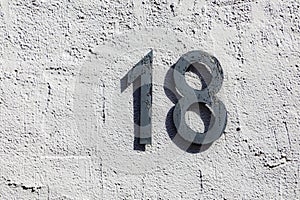 House number eighteen at a rough wall