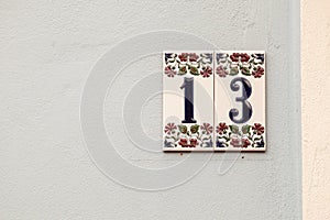 House number thirteen, sign at wall