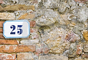 A house number twentyfive (25) on a wall in Pienza, Tuscany