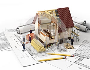 House with open interior on top of blueprints, documents and mortgage calculations and builders. Construction concept.