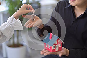 A house owner gives a house key to a real estate broker