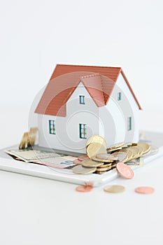 House ownership concept â€“ a model house on a pile of coins