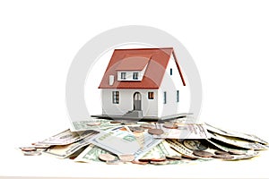 House ownership concept â€“ a model house on a pile of dollar bills