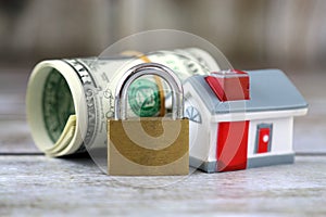 House, padlock and dollars. Conceptual image for investors in real estate and dollars. Security of money and real estate