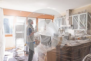 House painter paining the interior of a furnished house