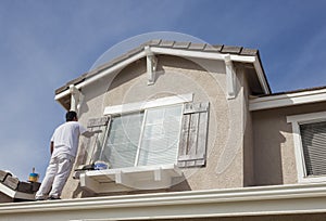 House Painter Painting the Trim And Shutters of Home