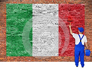 House painter paints flag of Italy on brick wall