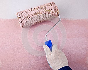 House painter using paint roller, painting wall