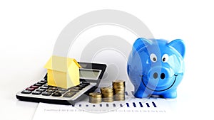 House paper on Calculator and coins and piggy bank for home Loan