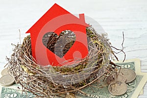 House paper with heart in nest on money background - Love for home, home insurance concept