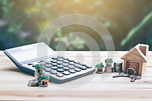 House placed on coins. houses, keys, calculators placed on a table.