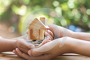 House placed on coins Men`s hand is planning savings money