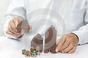 House placed on coins Men`s hand is planning savings money of coins to buy a home