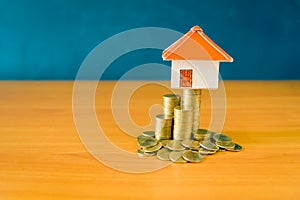 House placed on coins Men`s hand is planning savings money of coins to buy a home concept concept for property ladder, mortgage