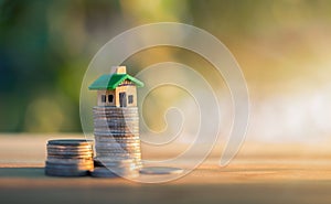 House placed on coins. planning savings money of coins to buy a home concept, concept for property ladder, mortgage and real