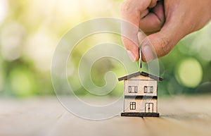 House is placed on the table. hands putting coins into the house. planning savings money of coins to buy a home concept for