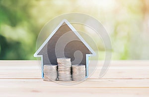 House placed on the table silver coins placed a piles. planning savings money of coins to buy a home